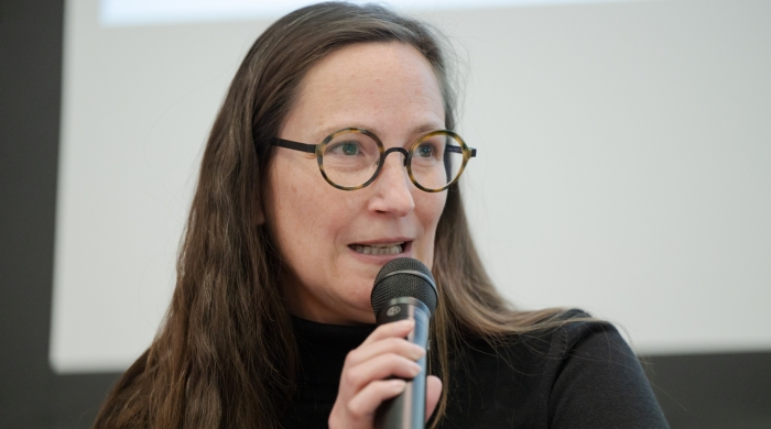 Dr. Raphaela Henze speaking into microphone