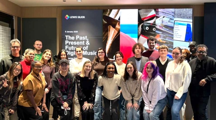 Students and faculty stand together for a group photo inside the Lewis Silkin office after a guest lecture, smiling toward the camera. 