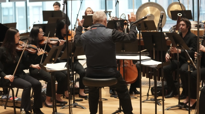 Chamber group practicing and being led by conductor