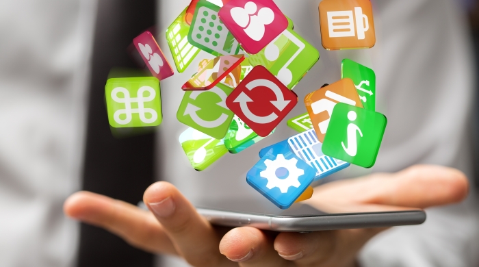 A collection of apps float above a smartphone screen in someone's hand. 
