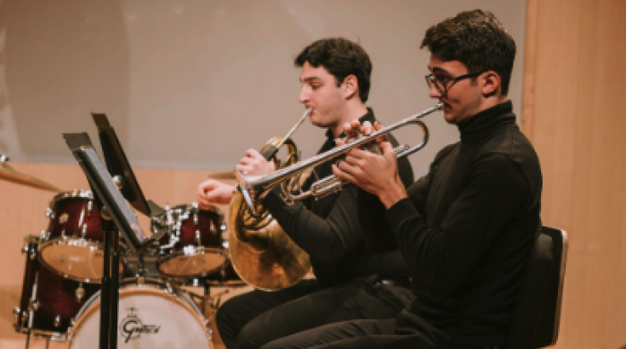 Two brass students practicing instruments