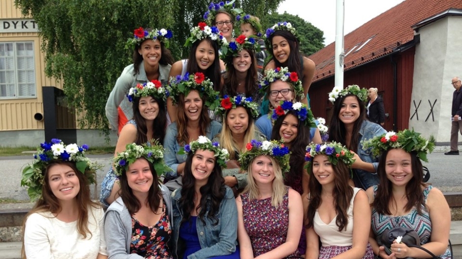 Students posing in Sweden wearing flower crowns.