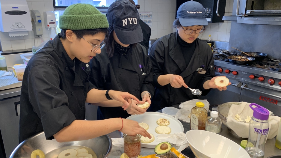 Three students working together to create an asian pear dish.