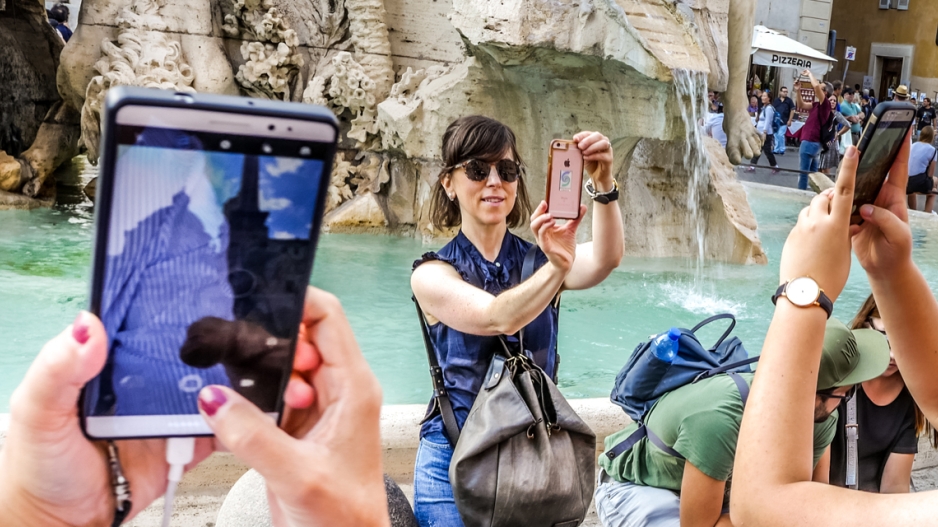 multiple tourists taking smart phone pictures