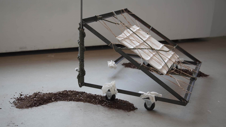 Sculpture with frame, string and soil. 