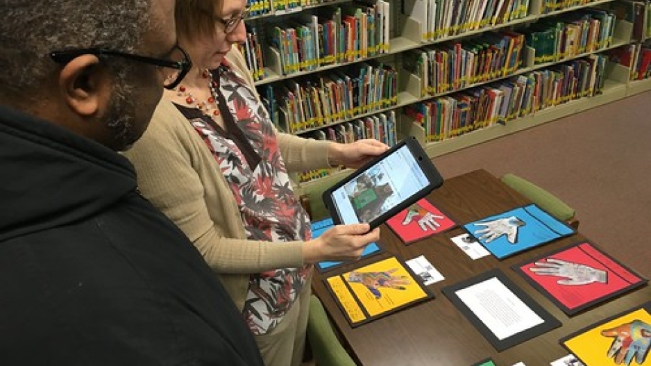 Two people staring at iPad in a library