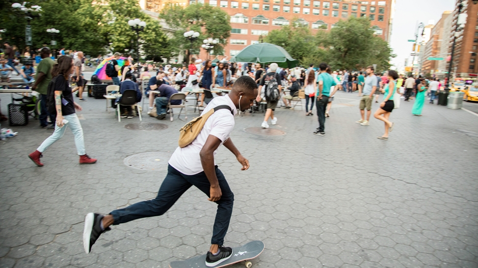 A skateboarder traveling across Union Square Park