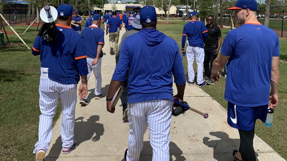 Mets team members walk to the clubhouse