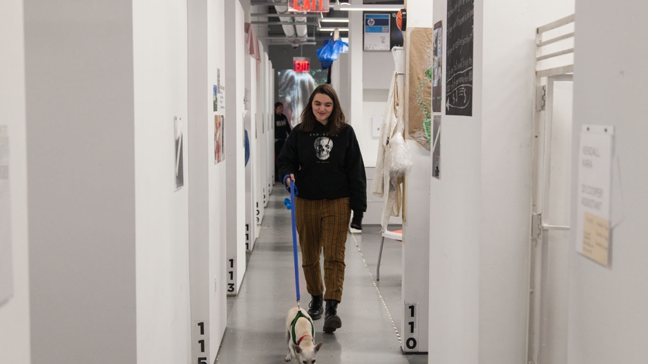 Student walking with dog in studios. 