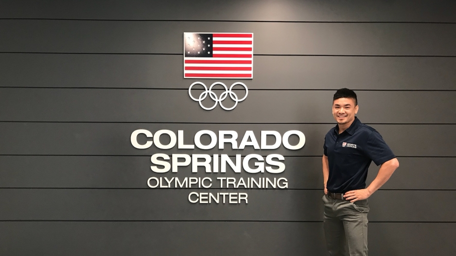 Robert standing in front of a sign for the Colorado Springs Olympic Training Center