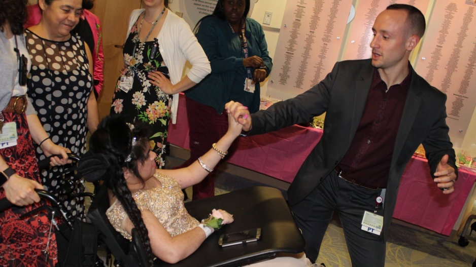 Zachary Gubitosi dancing with a patient in a wheelchair.