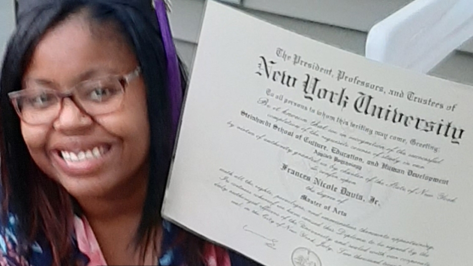woman smiling holding a degree