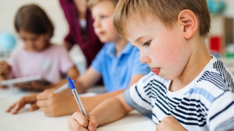 A child is drawing in a classroom