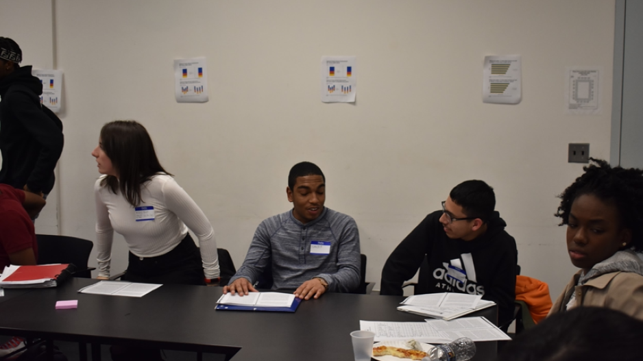 Students sit at a table during a quant gallery walk