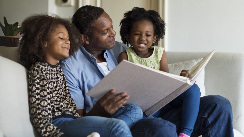 parent reading to two children