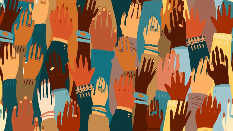 Raised hands of various skin tones and sweater colors. Some hands are adorned with jewelry and some hands are not.
