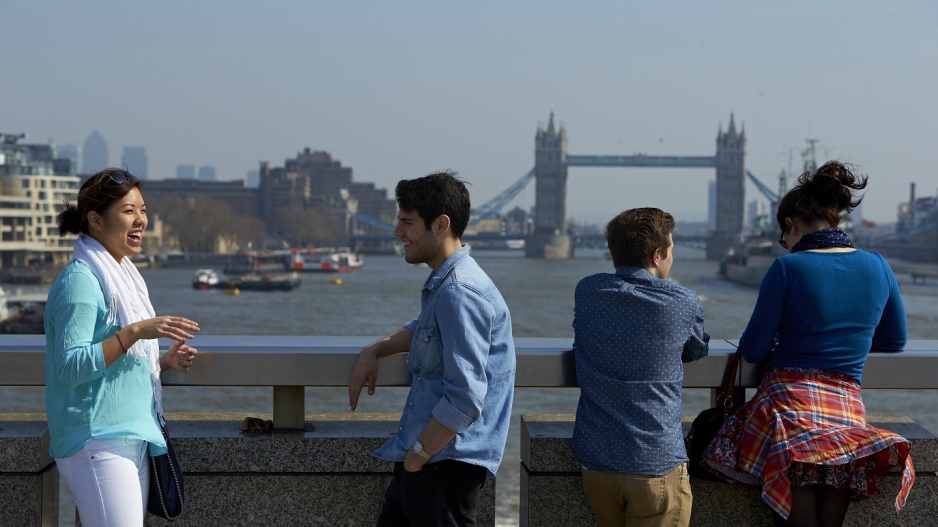 Students talking on a bridge in London