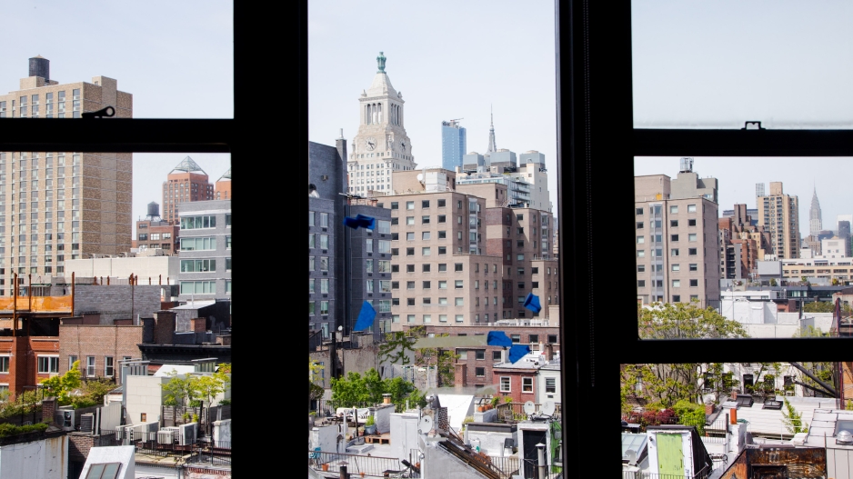 An photo taken from the BFA event space in the Barney Building. It's a view of the East Village in Manhattan broken up by thick back windowpanes.