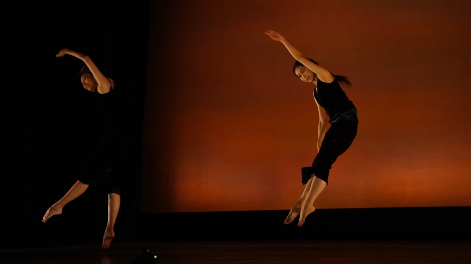 Two dancers mid air arching their backs