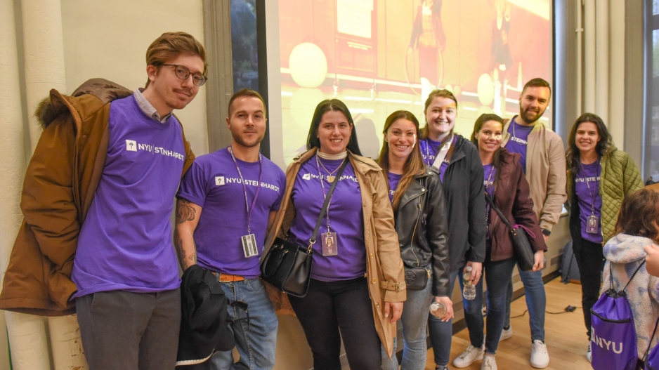 Volunteers for NYU Steinhardt's "Take Your Children to Work Day," dressed in purple t-shirts.