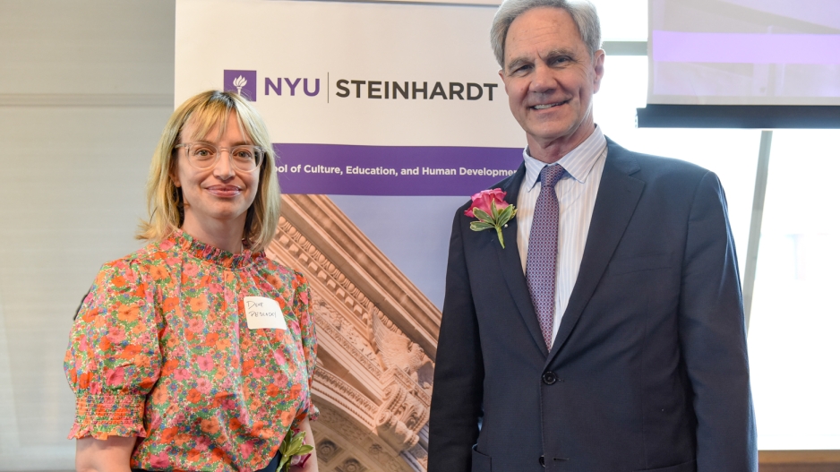 Dove Pedlosky and Jack H. Knott smile in front of a Steinhardt banner.