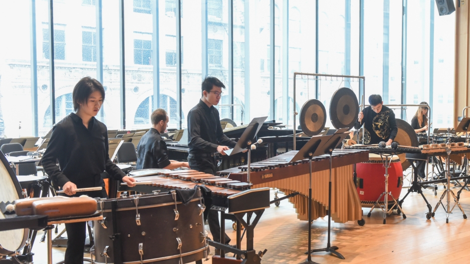 Percussion students performing in room with huge windows