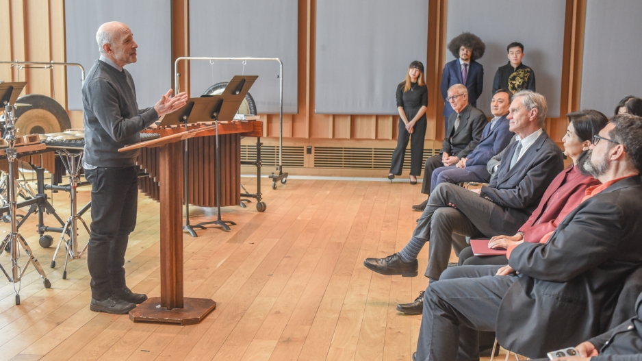 Professor standing at podium speaking to audience members