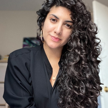 Headshot photo of Silvia with her curly hair