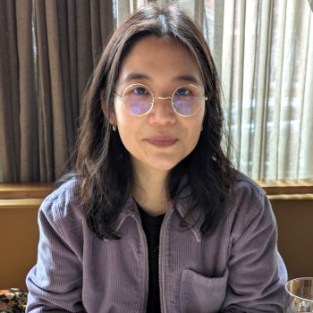 Sejin sitting with a purple jacket.