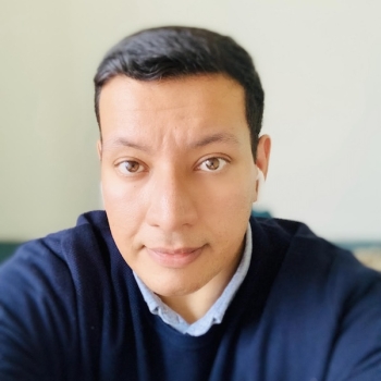 Man in blue sweater and light blue shirt.