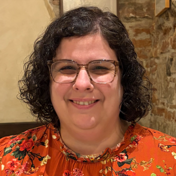 Daphna Harel: woman with brown curly hair wearing glasses