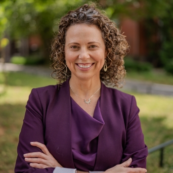 Woman with curly hair wearing purple blazer
