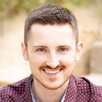 Headshot of Hunter Hanson wearing a red button up shirt with blue dots