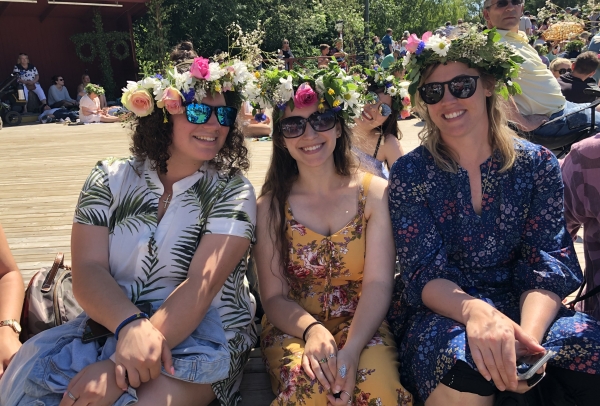 Three students wearing flower crowns to celebrate the Swedish Midsummer tradition.