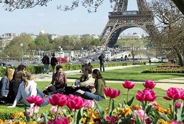 Students sitting on the grass near the Eiffel Tower