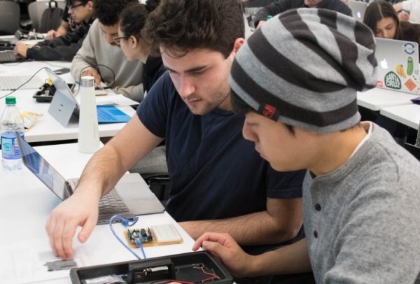 Two male students examine computer circuits 