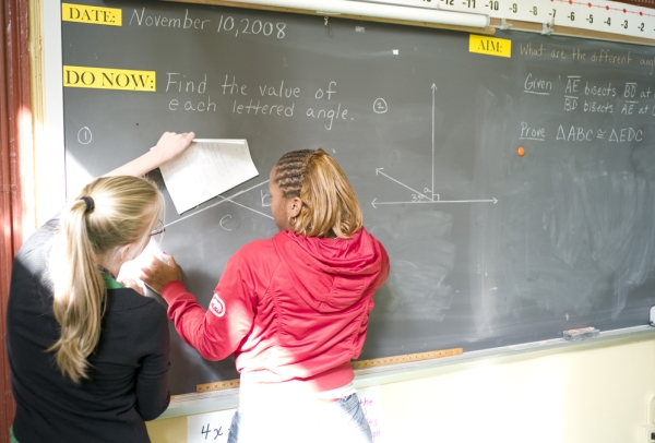 teacher and student working together on the chalkboard