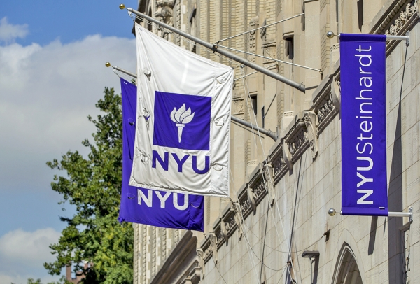 NYU flags flying on the side of a building