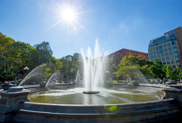 The Washington Square fountain on a bright sunny day looking east