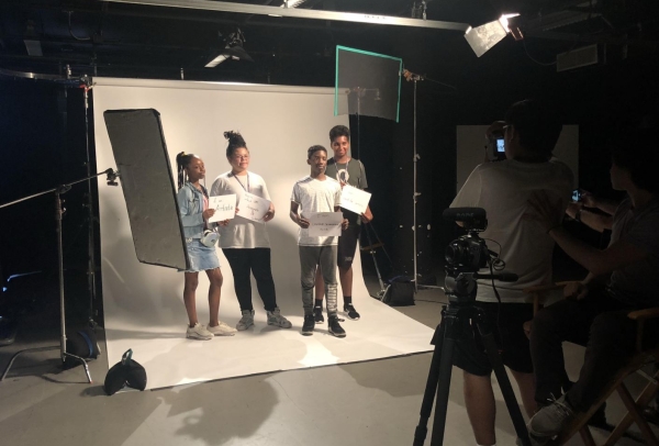 A behind-the-scenes photo of four students from the College & Career Lab in a photoshoot