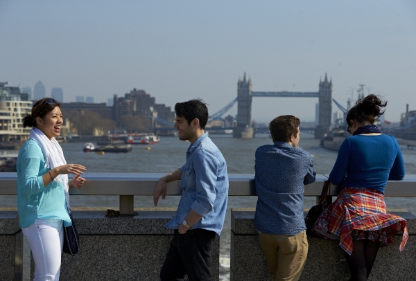 Students taking a break to talk on London Bridge while viewing Tower Bridge from afar