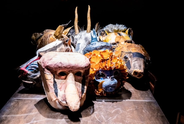 7 colorful paper mâché masks on a table depicting different animals