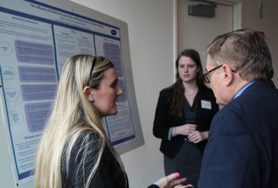 Student talking to faculty in front of poster