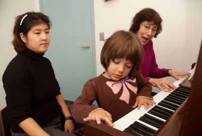 Child at Piano with Music Therapist