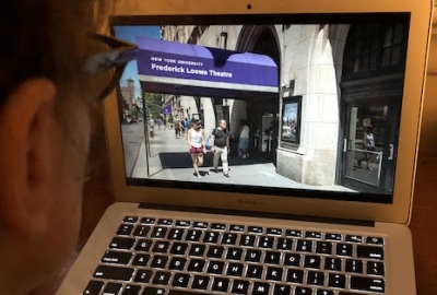 man looking at computer with NYU on screen