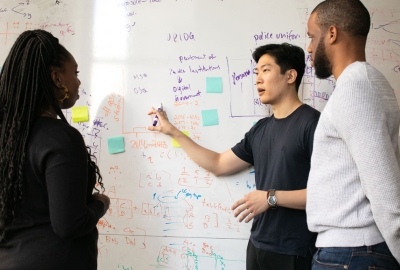 A group of applied statistics students working at a whiteboard