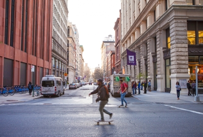 A skateboarder on Broadway racing past Washington Place 