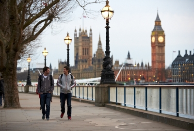 An image of NYU student walking down The Queen's Walk by River Thames with Big Ben in the background. 