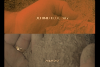 Behind Blue Sky, August 2021. Two photos, one tinted orange, of a hand filled with beige dirt 