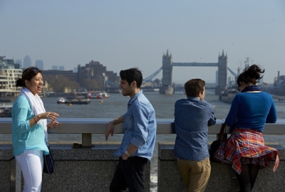 Students taking a break to talk on London Bridge while viewing Tower Bridge from afar